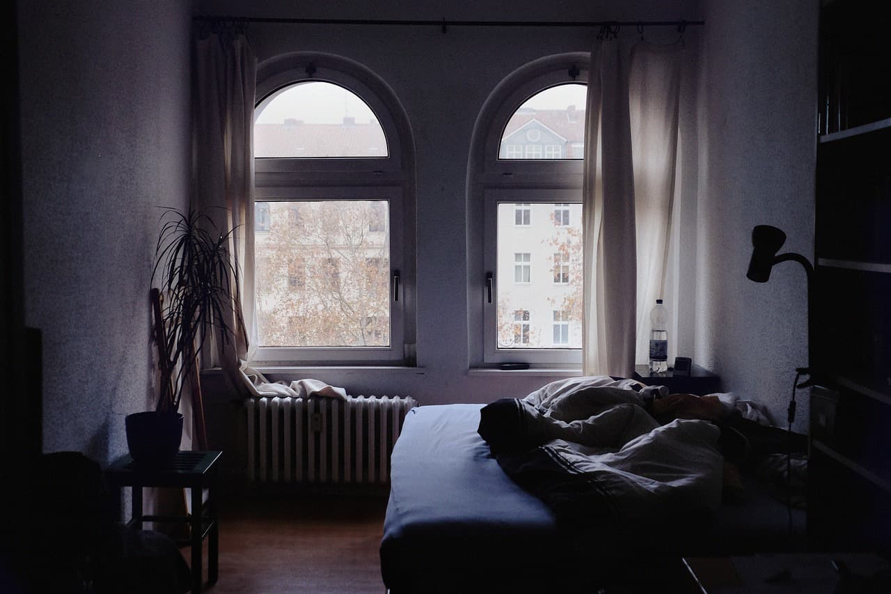 A radiator under a bedroom window at dusk