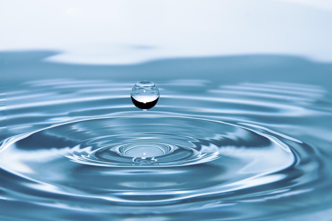 A single drop of water landing in still water